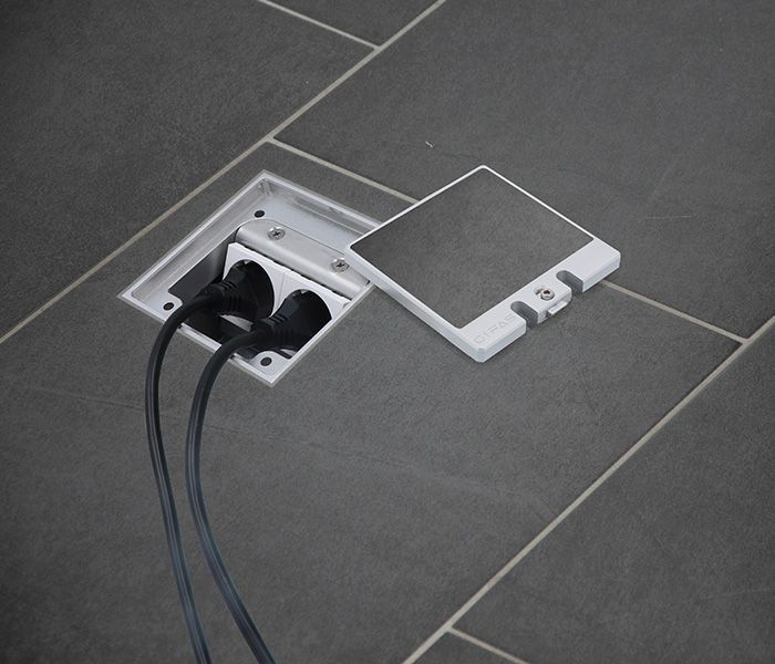 Presa di corrente a pavimento in casa con copertura per un'alimentazione discreta nella zona giorno