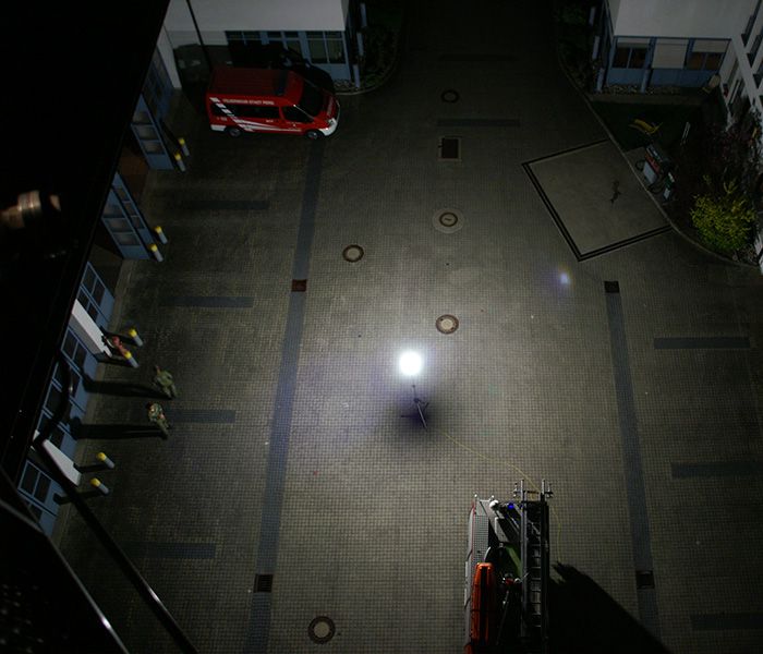 Mobiles Arbeitslicht beleuchtet einen Innenhof bei einem nächtlichen Rettungseinsatz