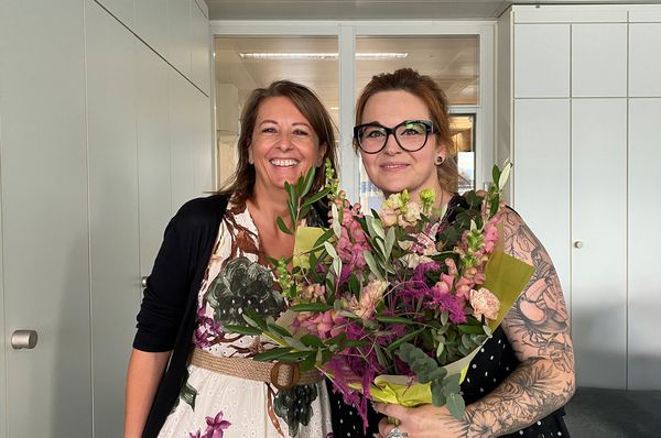 GIFAS Mitarbeitende feiern das Jubiläum von Kim Durst – Blumenstrauss und Glückwünsche im Büro in Rheineck.