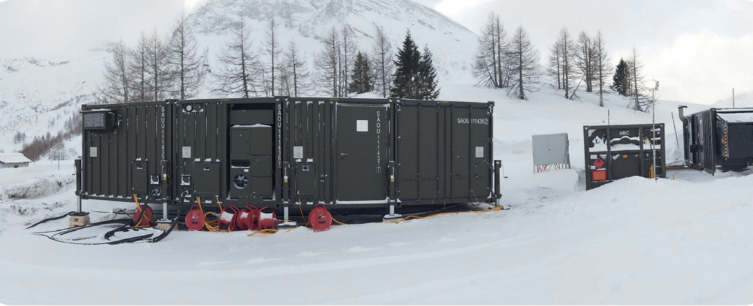 Mobile Stromversorgung mit robusten Kabelrollen und Containern im winterlichen Ausseneinsatz in den Bergen