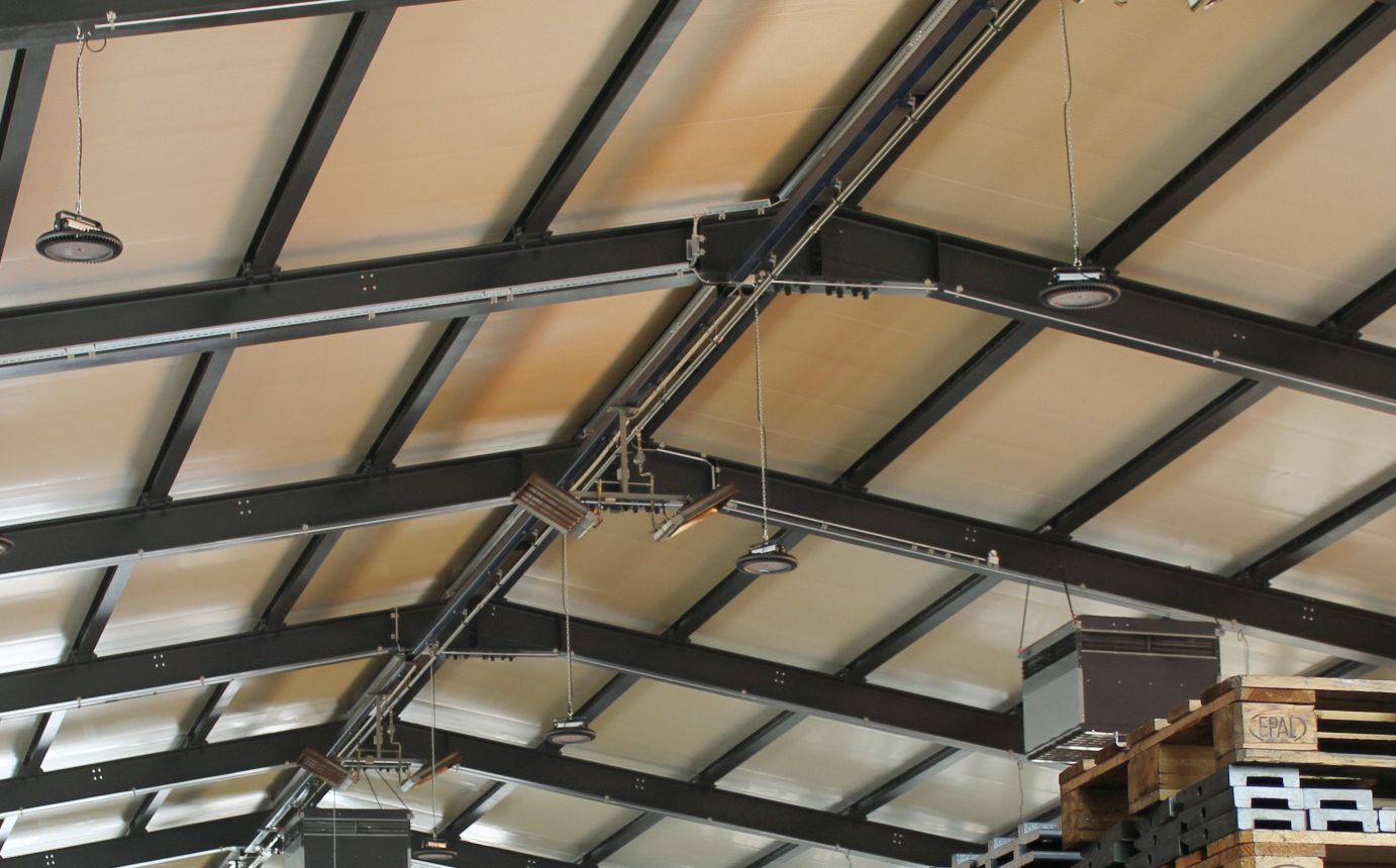 Bâtiment industriel avec plusieurs projecteurs intérieurs à LED montés sur la structure du toit - éclairage efficace des zones de production et de stockage