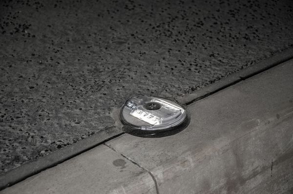 Detailaufnahme einer eingelassenen LED-Markierungsleuchte im Strassentunnel – robuste, bodennahe Orientierung für sichere Führung