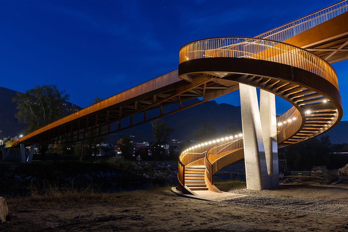 Ponte pedonale illuminato con rampa a spirale e sistema di guida a LED LaneLED per un percorso sicuro di notte