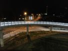 Pont cycliste de nuit avec éclairage LED continu - Piste cyclable sûre et bien éclairée au-dessus d'un carrefour routier