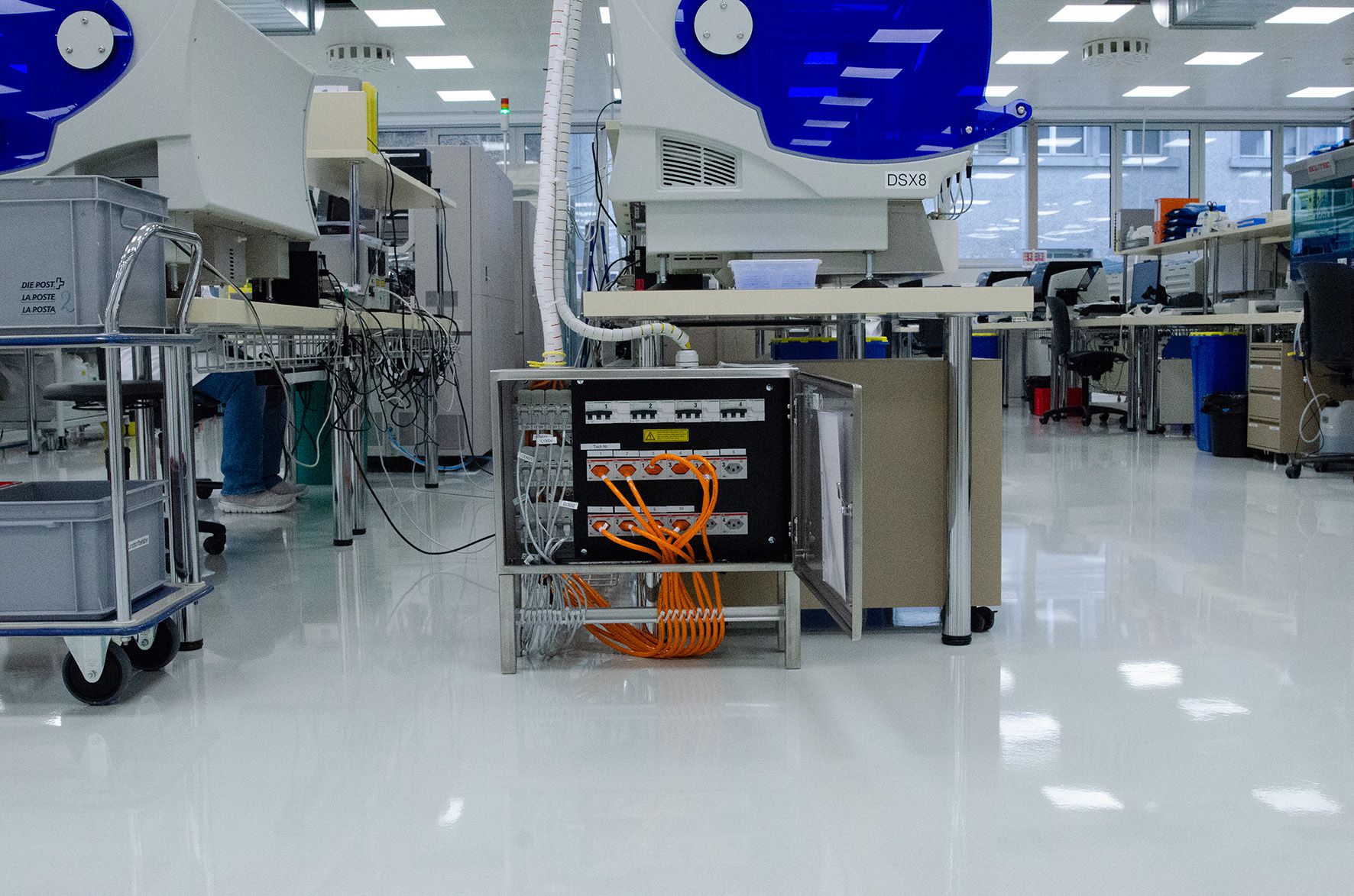 Impianto elettrico nel laboratorio di Goldach con quadro di distribuzione, cavi arancioni e macchine di prova industriali