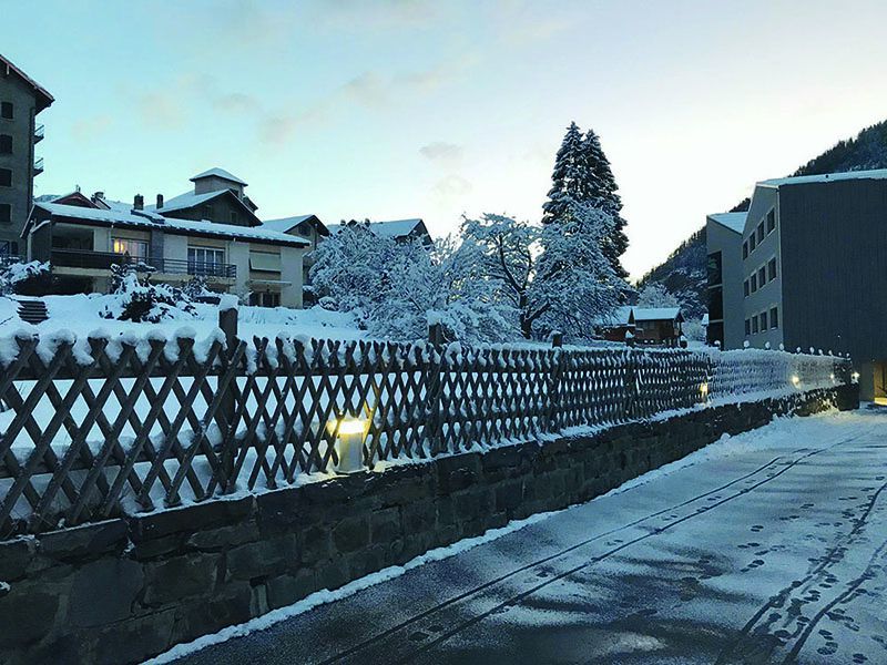 Des luminaires directionnels à LED éclairent un trottoir enneigé le long d'un quartier résidentiel et garantissent des chemins sûrs dans la commune