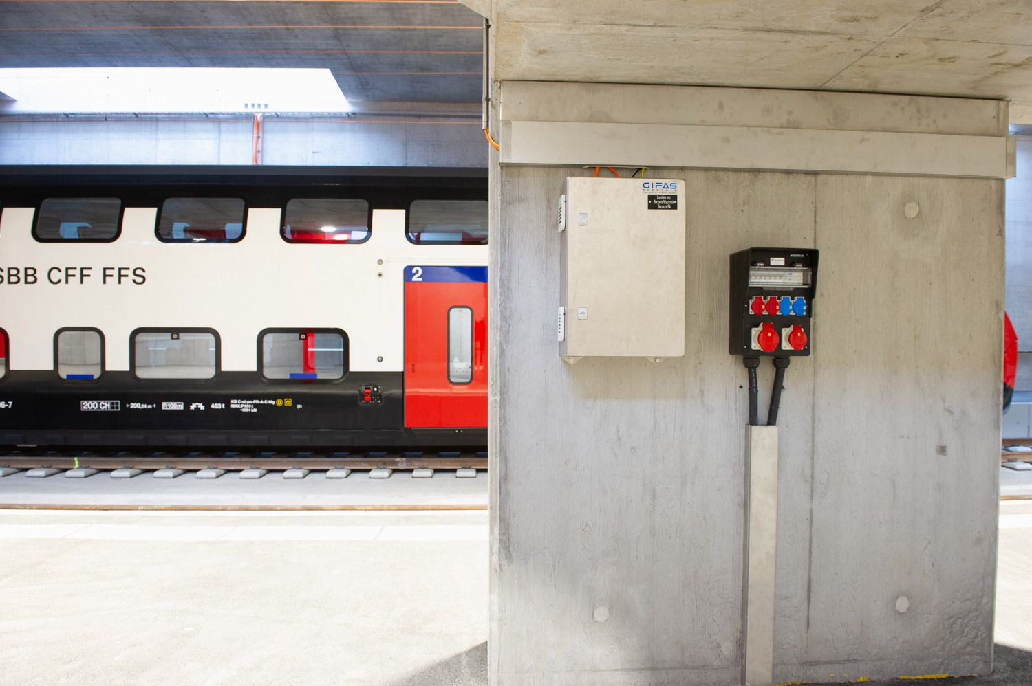 Power distributor and connection box from GIFAS in the station area in front of an SBB train - secure power supply for railroad infrastructure