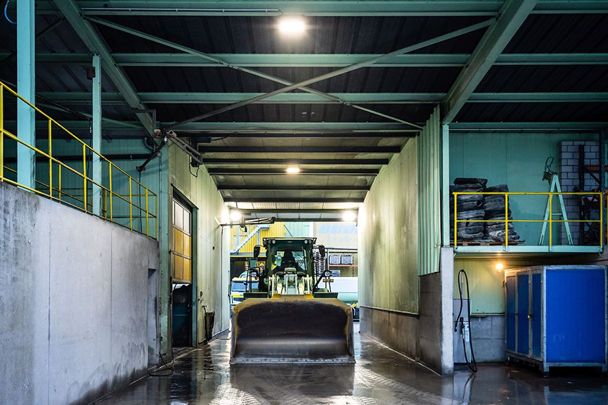 L'illuminazione LED AlphaLUXX in un autolavaggio industriale fornisce un'illuminazione chiara mentre una pala gommata entra per la pulizia