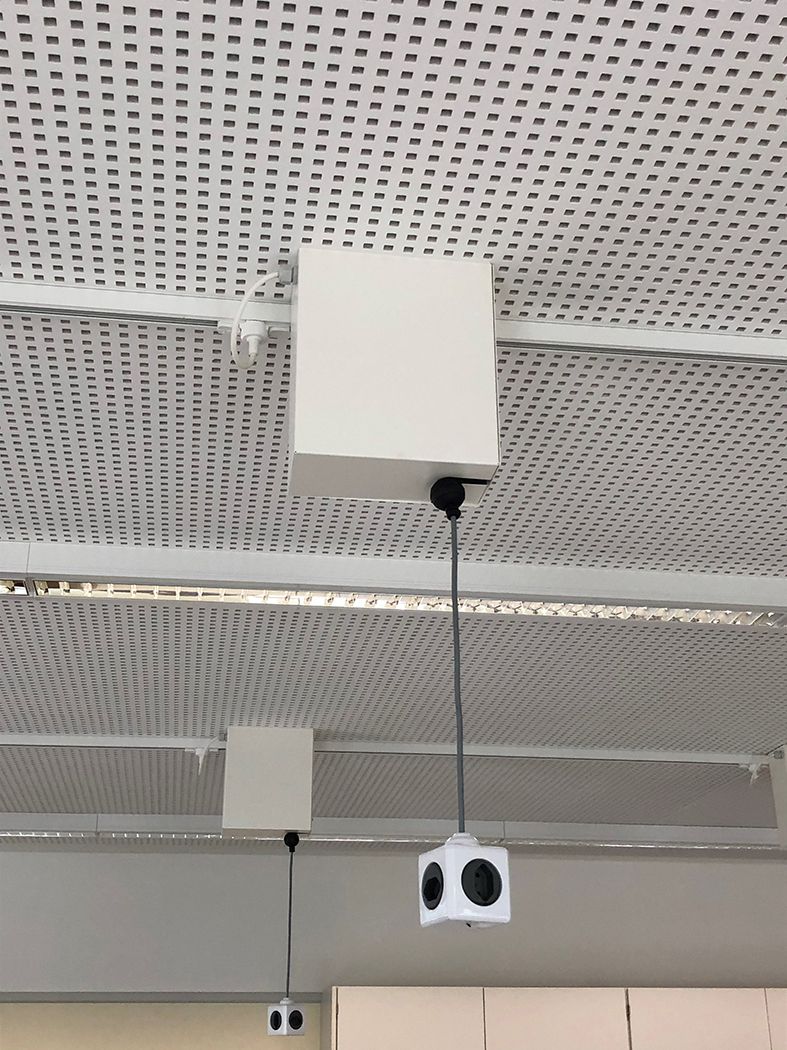Zugkabelrolle an der Decke eines Klassenzimmers zur sicheren Stromversorgung von Arbeitsplätzen