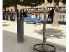 Closed GIFAS power supply bollard installed along a waterfront promenade with benches and trees for discreet outdoor power distribution