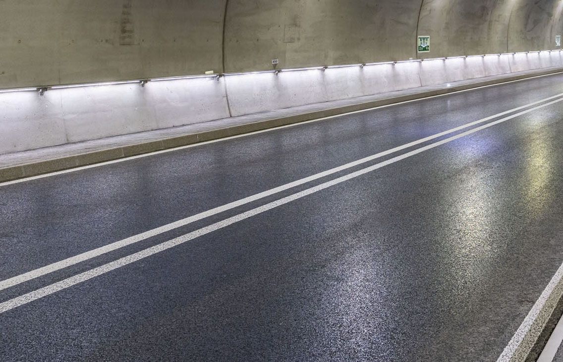 Tunnel routier avec éclairage LED continu le long des parois pour un guidage sûr de la voie et une bonne visibilité
