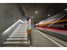 Illuminated station stairs with LED handrail and passing train - safe routing and modern lighting in the station platform